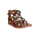 a pair of brown leather sandals with turquoise stones